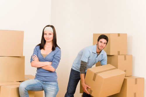 Removalists handling boxes and furniture in a Norwegian apartment move
